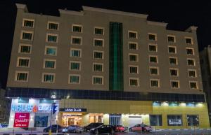 a large building with cars parked in front of it at فندق دولف in Al Khobar