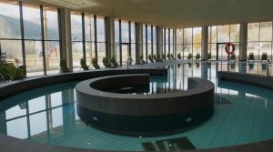 a large swimming pool in a building with windows at Bella Vista Apartments in Nauders