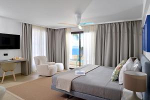 a bedroom with a bed and a view of the ocean at Althea Resort in Áno Loutrón