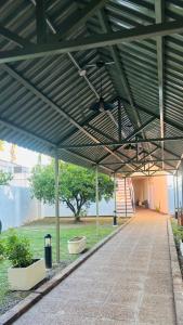 awning over a sidewalk in a building with a tree at Hotel las ruedas by Choca in Arroyito