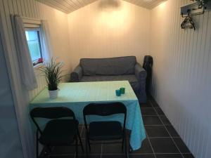 Ein Tisch und Stühle in einem kleinen Zimmer mit einer Couch in der Unterkunft Ore Strandcamping in Vordingborg