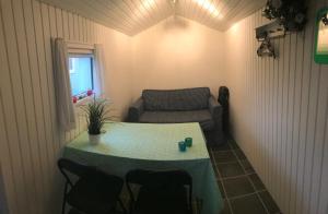 ein kleines Zimmer mit einem Tisch und einem Sofa in der Unterkunft Ore Strandcamping in Vordingborg