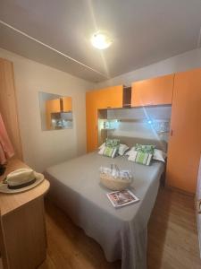 a bedroom with a large bed with a basket on it at Camping I Melograni in Marina di Bibbona