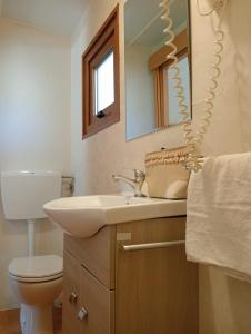 a bathroom with a sink and a toilet and a mirror at Camping I Melograni in Marina di Bibbona +96 photos