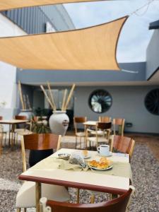 a table and chairs with a plate of food on it at Hotel las ruedas by Choca in Arroyito