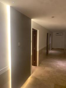 an empty room with a hallway with a door and a tile floor at Hotel room in Salalah