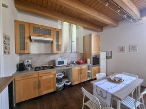 a kitchen with wooden cabinets and a table with chairs at Casetta gialla in Brianza - Monticello Brianza - NON E' CASATENOVO in Casatenovo