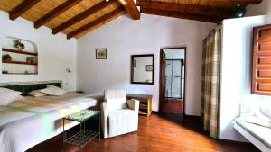 a bedroom with a bed and a chair in a room at Cortijo Lagar de Luisa in Borge