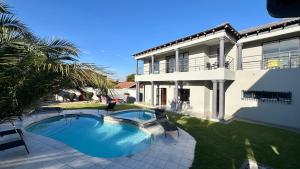 a swimming pool in front of a house at Nyasa Villa in Southgate