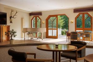 a living room with a table and a piano at Leonardo Med Spa Resort in Nondorf