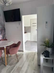 a dining room with a table and chairs and a kitchen at Apartament nad jeziorem in Lubkowo