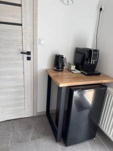 a desk with a microwave and a television on it at Apartament nad jeziorem in Lubkowo +10 photos