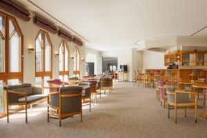 a dining room with chairs and tables and windows at Leonardo Med Spa Resort in Nondorf