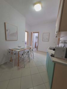 a kitchen with a table and chairs in a room at Mimosa Apartment in Vlorë