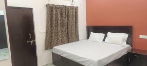 a small bedroom with a bed and a window at kanakdhara aashraya in Vrindāvan