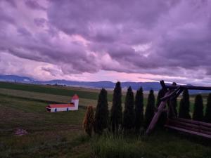 Eine Scheune auf einem Feld mit Zaun und Bäumen in der Unterkunft Mongol champing in Cotormani