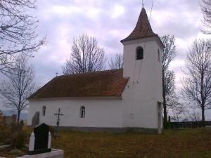eine weiße Kirche mit einem Kirchturm auf einem Feld in der Unterkunft Mongol champing in Cotormani
