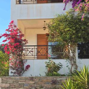 a house with a balcony with pink flowers at Marmari Sunset View in Marmari
