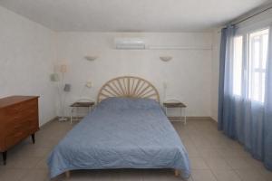 a bedroom with a bed and a dresser and a window at Appartement Coloquinte-Résidence Les Glycines in Eugénie-les-Bains