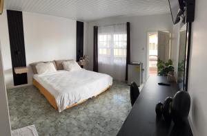 ein Schlafzimmer mit einem großen weißen Bett und einem Tisch in der Unterkunft Zenaida in Paramaribo
