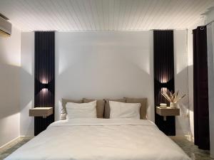 ein Schlafzimmer mit einem großen Bett mit weißen Laken und Kissen in der Unterkunft Zenaida in Paramaribo
