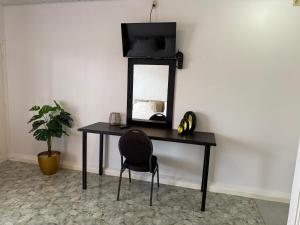 ein Schreibtisch mit Spiegel und Stuhl in einem Zimmer in der Unterkunft Zenaida in Paramaribo