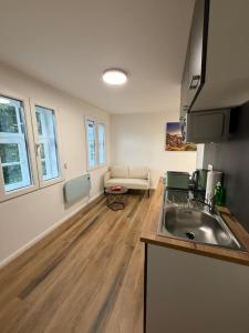 a kitchen with a sink and a couch in a room at Bartenwetzer Schleusenhaus 1 in Melsungen