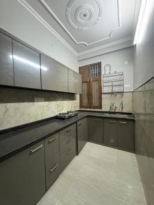 a large kitchen with gray cabinets and a ceiling at Entire 2Bhk Flat with a big Balcony in Jaipur