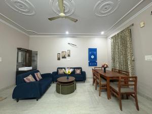 a living room with a blue couch and a table at Entire 2Bhk Flat with a big Balcony in Jaipur
