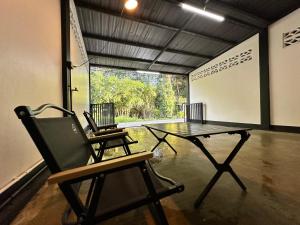 a ping pong table and two chairs in a room at Krabi Buddy House in Ban Khlong Chi Lat