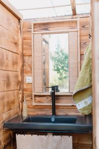a sink in a tiny house with a window at Le Bunker Secret - Logement Insolite in Florensac
