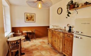 a kitchen with a table and a refrigerator at Le Fourneau Rond in Soings-en-Sologne