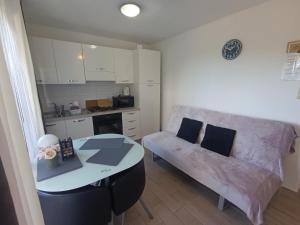 a kitchen and a living room with a table and a couch at Apartments Emi & Nini in Šibenik