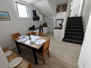 a dining room with a table and chairs and a staircase at Antonio Appartement in Steinabrückl