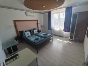 a bedroom with a bed with blue pillows on it at Sunrise Apartmanház in Balatonfüred