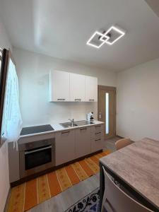 a kitchen with white cabinets and a stove at Domos de Budroni B&B in Bono +49 photos