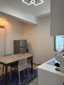 a kitchen with a table and chairs and a refrigerator at Domos de Budroni B&B in Bono