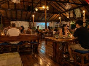 a group of people sitting at tables in a restaurant at Vanara Resort in Ko Chang