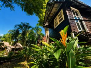 a black house with palm trees in front of it at Vanara Resort in Ko Chang +26 photos