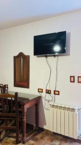 a room with a table and a television on a wall at Hotel las ruedas by Choca in Arroyito