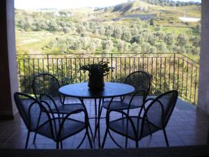un tavolo con sedie e un vaso sul balcone di Tenuta Agrituristica Castellesi a Squillace Altre 85 foto