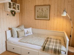 a bed in a room with wooden walls at Emma's Vintage Ferienhaus mit Kamin in Friedrichsbrunn +10 photos