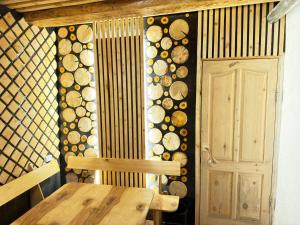 a room with a wooden table and a wall with logs at Crown Inn & Spa in Karakol