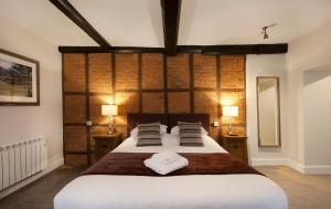 a bedroom with a large bed with two towels on it at The Talbot Hotel in Ledbury