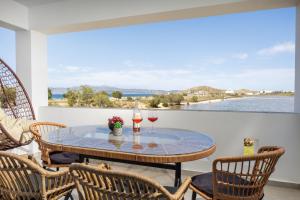 a patio with a table with two glasses of wine at Alykes Studios & Suites in Agios Prokopios