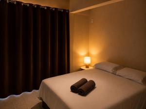 a bedroom with a bed with two towels on it at Hotel Confort in Quixadá