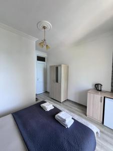 a white room with a bed with two towels on it at Zuri Kvariati in Kvariati