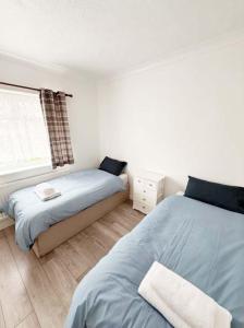 a bedroom with two beds and a window at Park View in Goodmayes