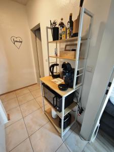 a room with a table with a coffee maker on a shelf at Monica Donau in Passau