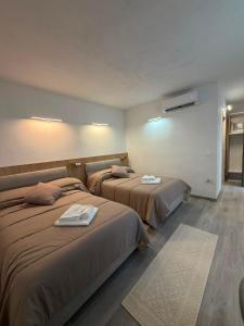 a hotel room with two beds with towels on them at Domos de Budroni B&B in Bono